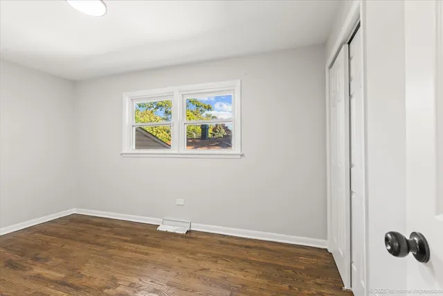 a view of an empty room with painting on the wall and a window