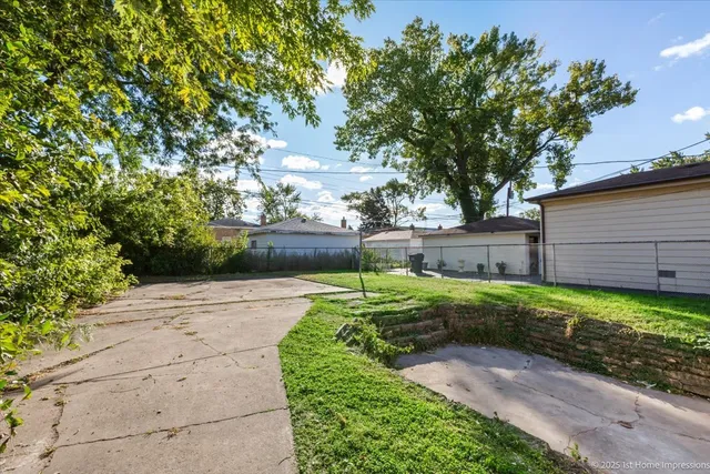 a view of backyard with wooden fence