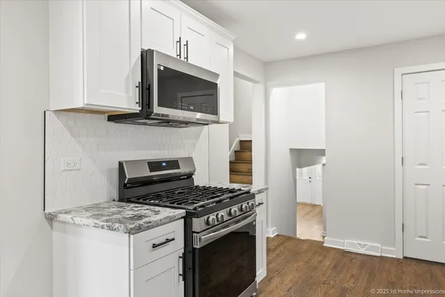 a kitchen with granite countertop a stove and a microwave