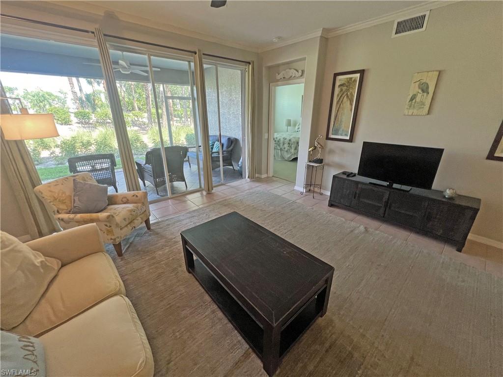 9261 Spring Run Boulevard, Unit 2407 Estero, FL 34135 - Photo 13 of 24 Living room featuring a healthy amount of sunlight, tile flooring, and ornamental molding