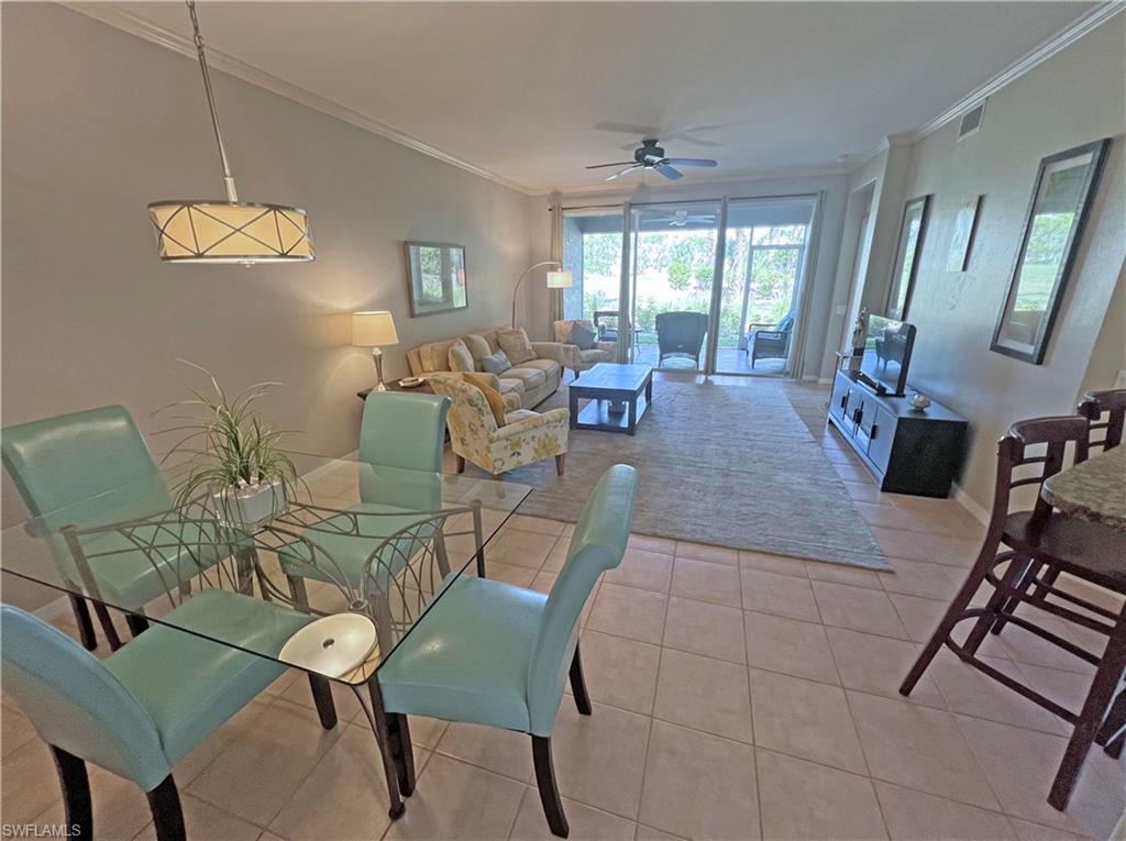 9261 Spring Run Boulevard, Unit 2407 Estero, FL 34135 - Photo 2 of 24 Dining and living room featuring ornamental molding, ceiling fan, and light tile flooring