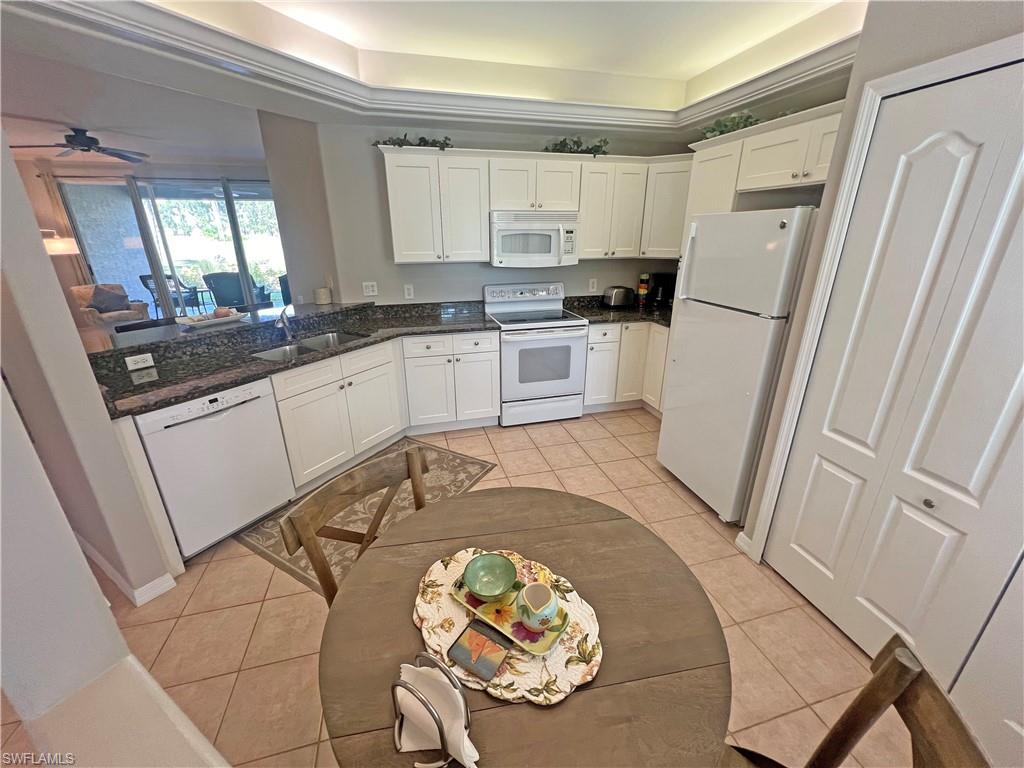 9261 Spring Run Boulevard, Unit 2407 Estero, FL 34135 - Photo 6 of 24 Kitchen with granite countertops, sink, white modern cabinets, crown lighting, and light tile floors