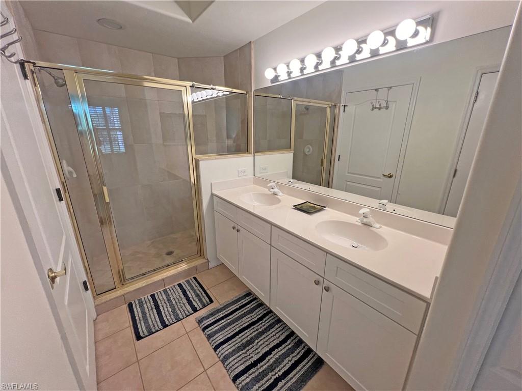 9261 Spring Run Boulevard, Unit 2407 Estero, FL 34135 - Photo 9 of 24 Master bathroom with a shower with door, tile flooring, and dual vanity