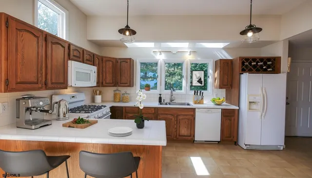 a kitchen with stainless steel appliances kitchen island granite countertop a table chairs in it and wooden floors