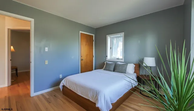 a bedroom with a bed and a wooden floor