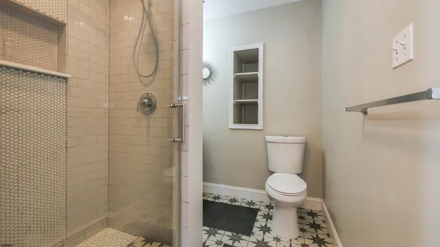 a bathroom with a toilet and a shower