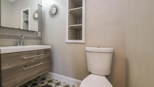 a bathroom with a toilet a sink and mirror