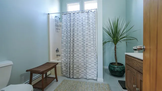 a bathroom with a toilet and a shower curtain