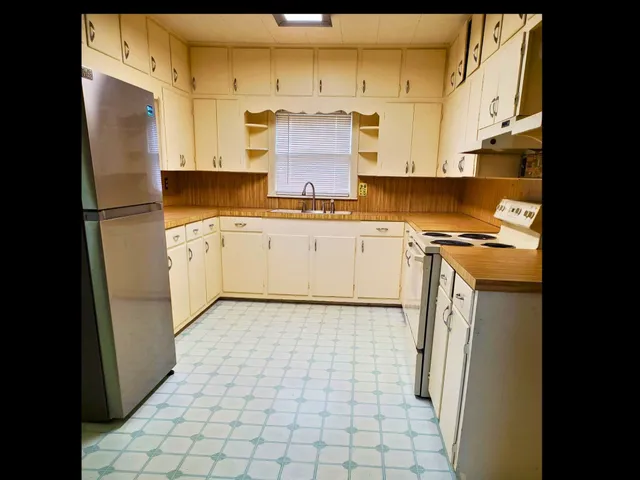 a kitchen with a stove a refrigerator and cabinets