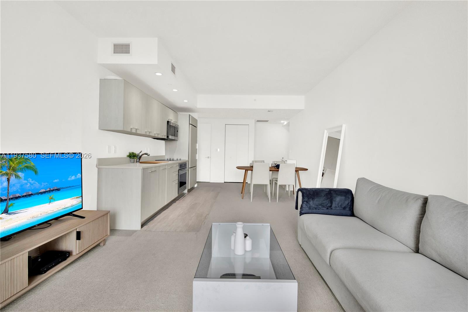 45 Southwest 9th Street, Unit 1609 Miami, FL 33130 - Photo 11 of 39 a living room with furniture and a flat screen tv