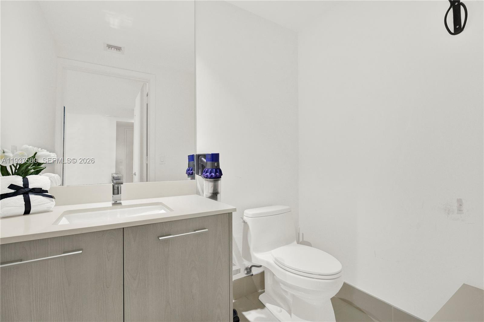 45 Southwest 9th Street, Unit 1609 Miami, FL 33130 - Photo 12 of 39 a bathroom with a sink toilet and a mirror