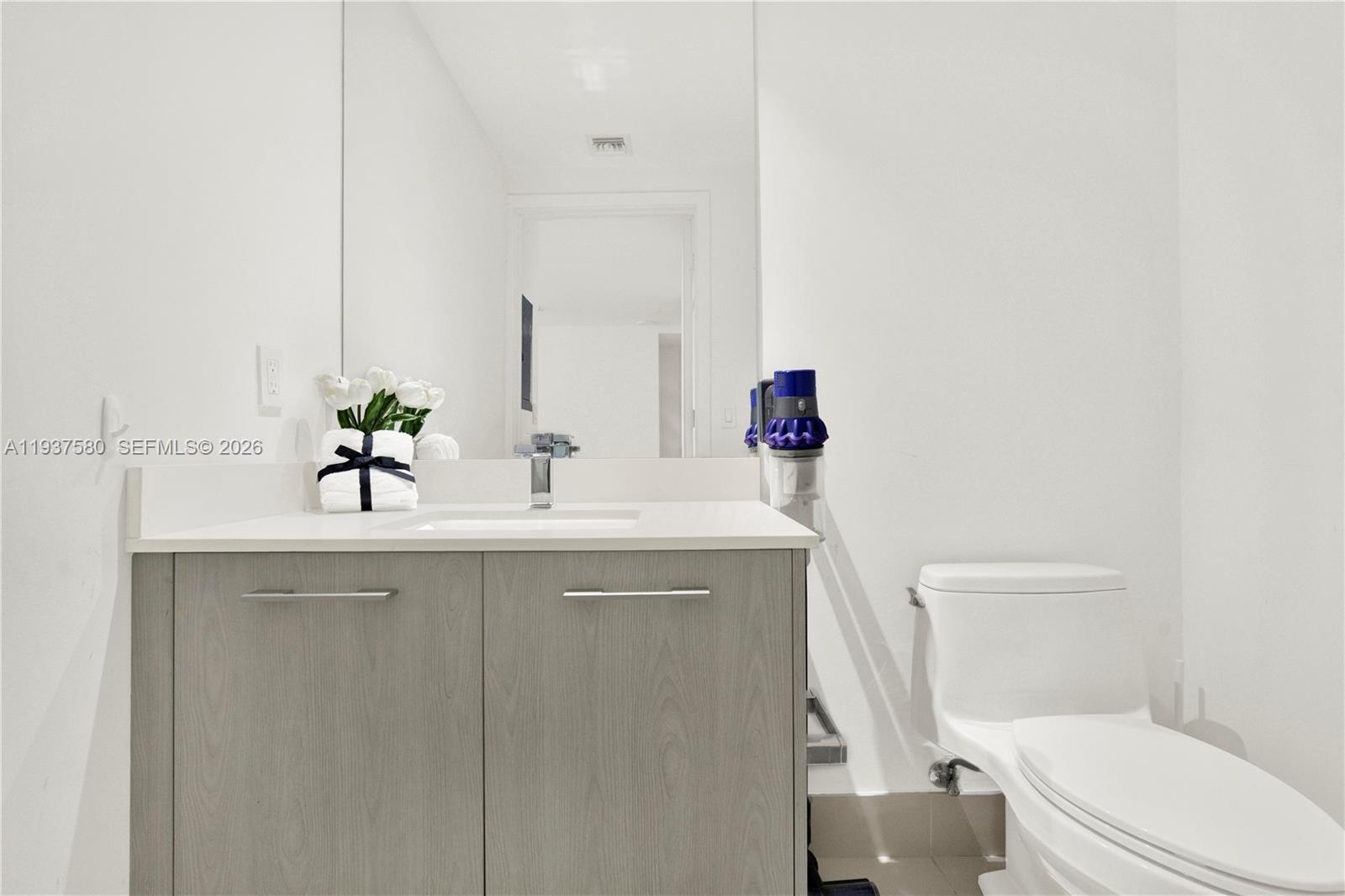 45 Southwest 9th Street, Unit 1609 Miami, FL 33130 - Photo 13 of 39 a bathroom with a sink a toilet and mirror