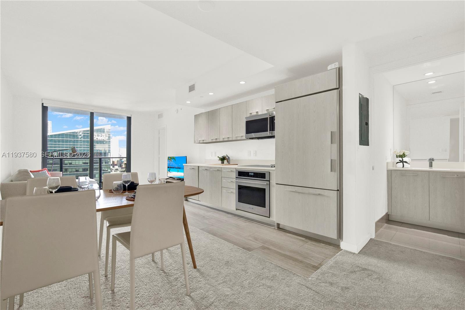 45 Southwest 9th Street, Unit 1609 Miami, FL 33130 - Photo 2 of 39 a kitchen with a refrigerator a stove top oven a sink dishwasher and white cabinets with wooden floor
