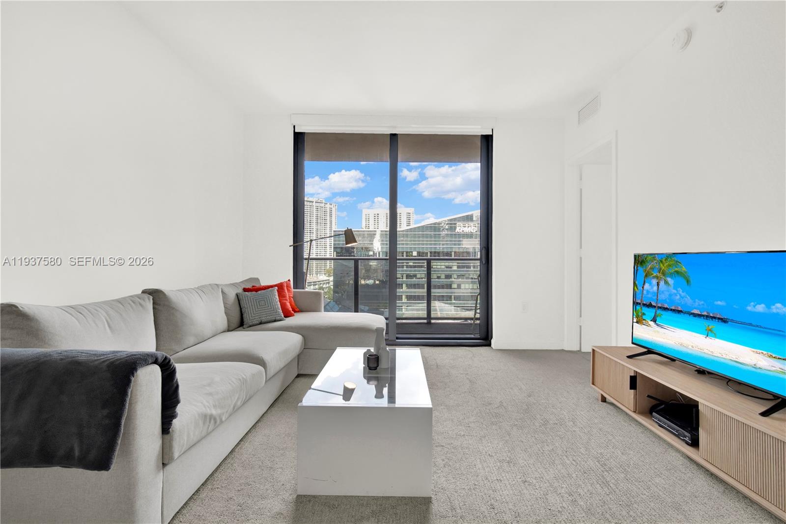 45 Southwest 9th Street, Unit 1609 Miami, FL 33130 - Photo 8 of 39 a living room with furniture and a flat screen tv
