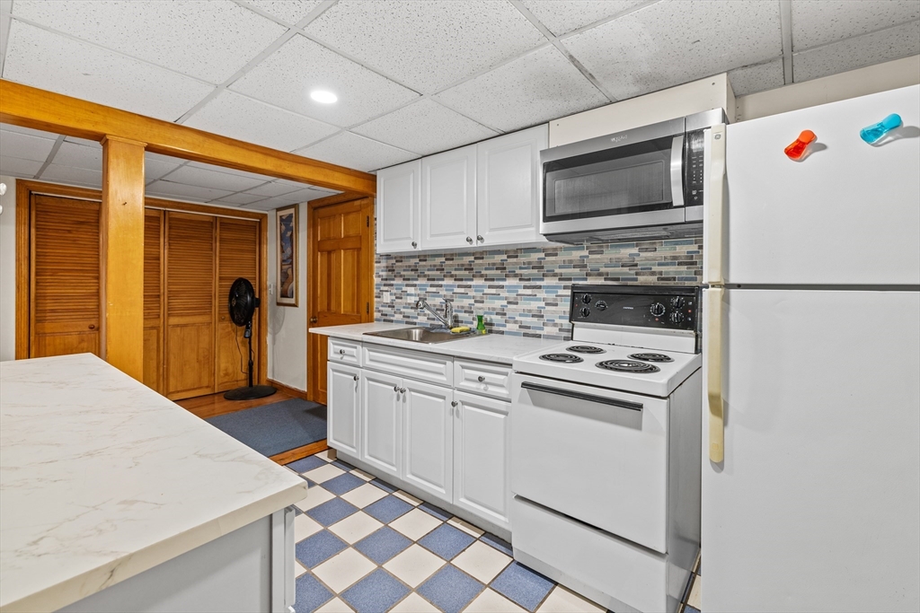 450 Skunknet Road Barnstable, MA 02632 - Photo 25 of 42 a kitchen with stainless steel appliances granite countertop a stove microwave and refrigerator