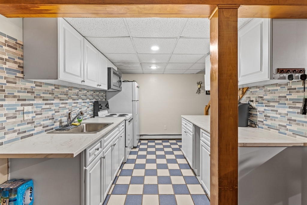 450 Skunknet Road Barnstable, MA 02632 - Photo 26 of 42 a kitchen with a sink and a refrigerator