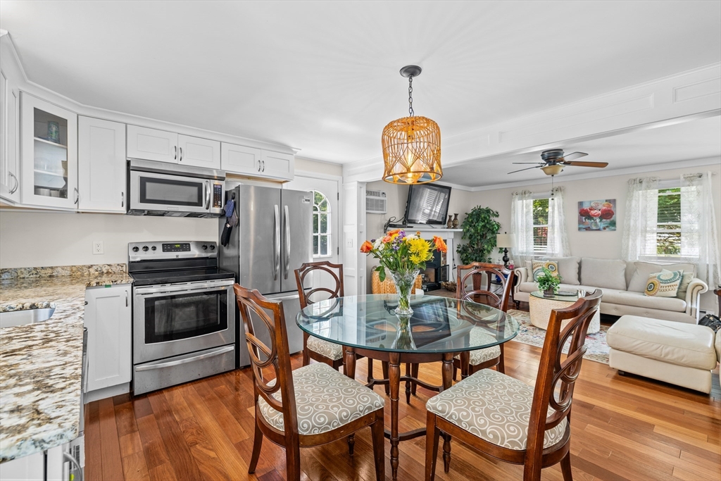 450 Skunknet Road Barnstable, MA 02632 - Photo 3 of 42 a view of a dining room with furniture a chandelier and wooden floor
