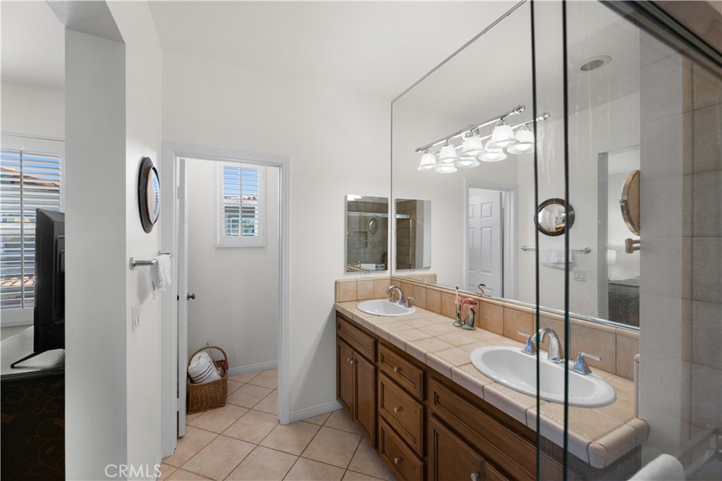 122 Jadestone Irvine, CA 92603 - Photo 18 of 20 a bathroom with a granite countertop sink a toilet a mirror and shower