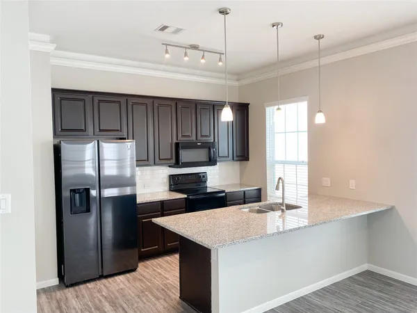 a kitchen with kitchen island a sink appliances and cabinets