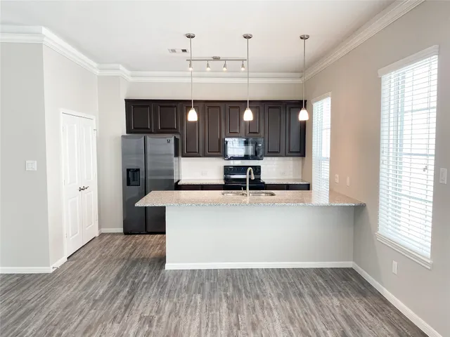 a view of kitchen with sink microwave refrigerator and outdoor view