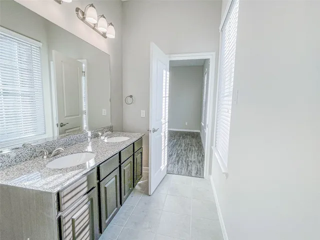 a spacious bathroom with a granite countertop sink and a mirror