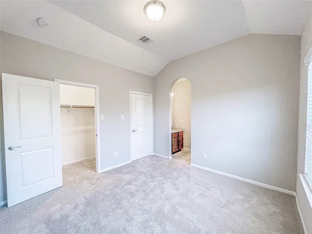 an empty room with closet and mirror