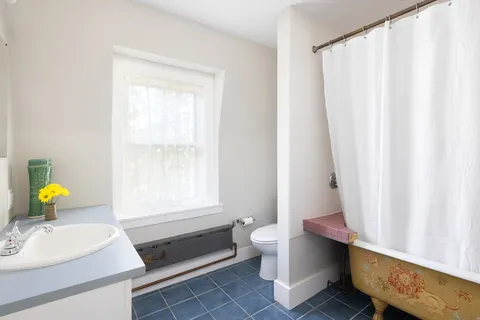 a bathroom with a sink toilet and window