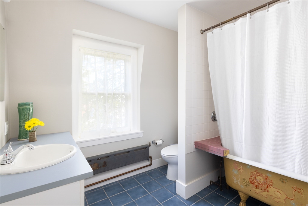 135 Langley Road Newton, MA 02459 - Photo 18 of 20 a bathroom with a sink toilet and window