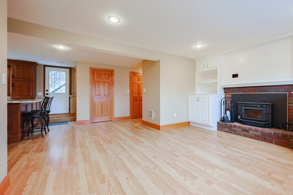 68 Greene Street, Unit A Hopedale, MA 01747 - Photo 11 of 26 an empty room with wooden floor and fireplace