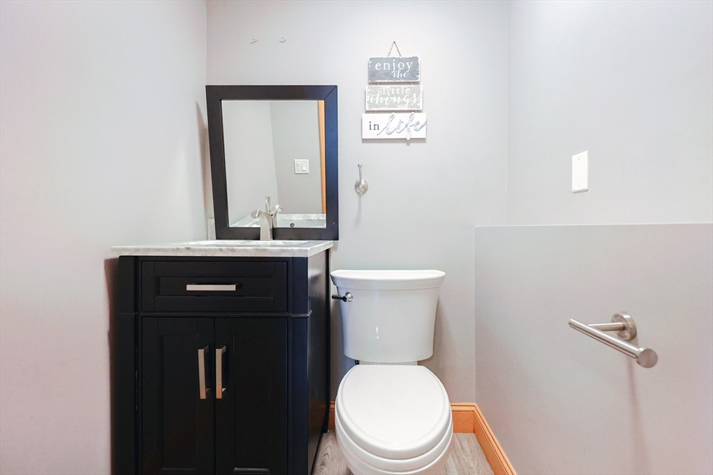 68 Greene Street, Unit A Hopedale, MA 01747 - Photo 19 of 26 a bathroom with a toilet a sink and mirror