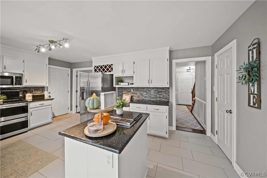 13441 Bailey Bridge Road Midlothian, VA 23112 - Photo 13 of 48 a open kitchen with stainless steel appliances granite countertop a stove top oven a refrigerator and a dining table with wooden floor