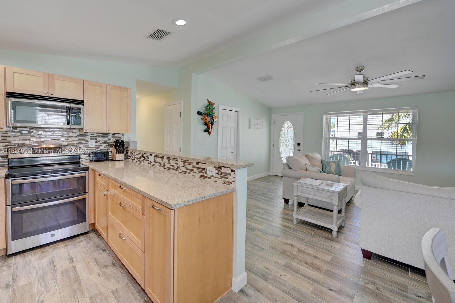 239 Lower Matecumbe Road Key Largo, FL 33037 - Photo 20 of 70 a kitchen with stainless steel appliances granite countertop a stove and a refrigerator
