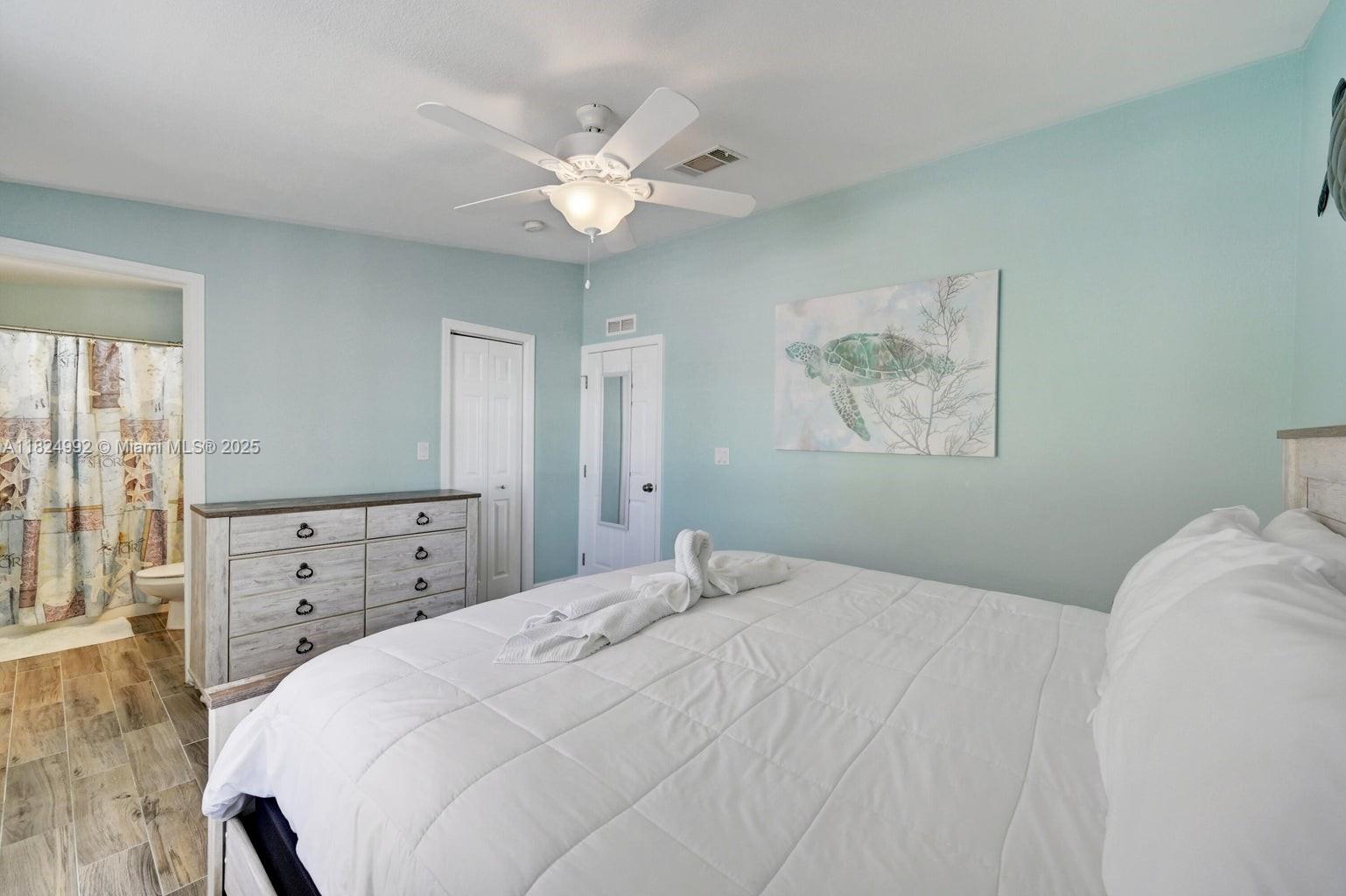 239 Lower Matecumbe Road Key Largo, FL 33037 - Photo 31 of 70 a bedroom with a bed and a chandelier