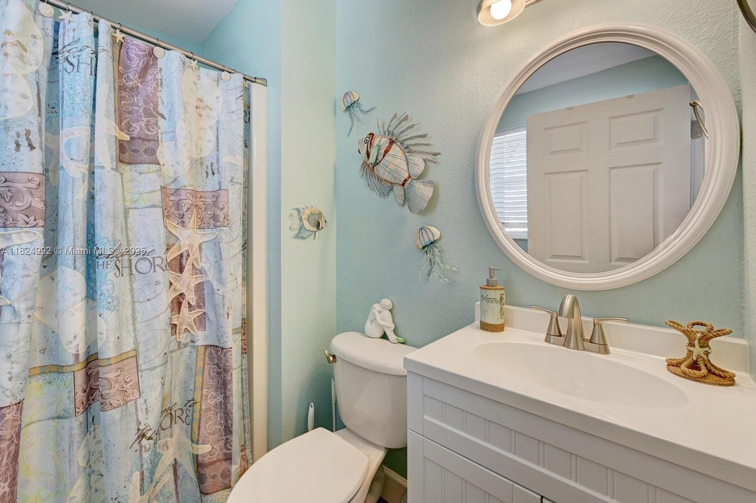 239 Lower Matecumbe Road Key Largo, FL 33037 - Photo 33 of 70 a bathroom with a sink a toilet and a mirror