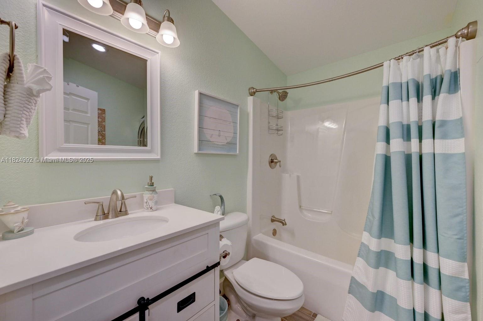 239 Lower Matecumbe Road Key Largo, FL 33037 - Photo 10 of 70 a bathroom with a sink a toilet a mirror a vanity and shower