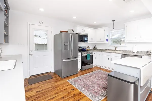 a kitchen with a sink refrigerator and microwave
