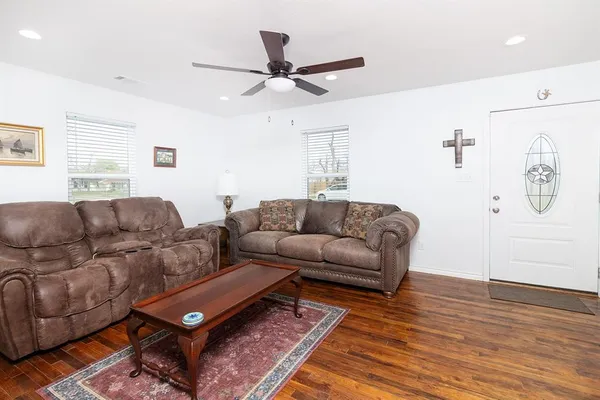 a living room with furniture and a wooden floor