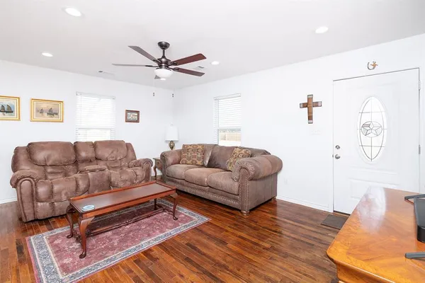 a living room with furniture and a wooden floor