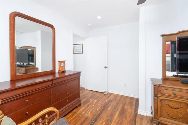 a room with a bed and a mirror on dresser