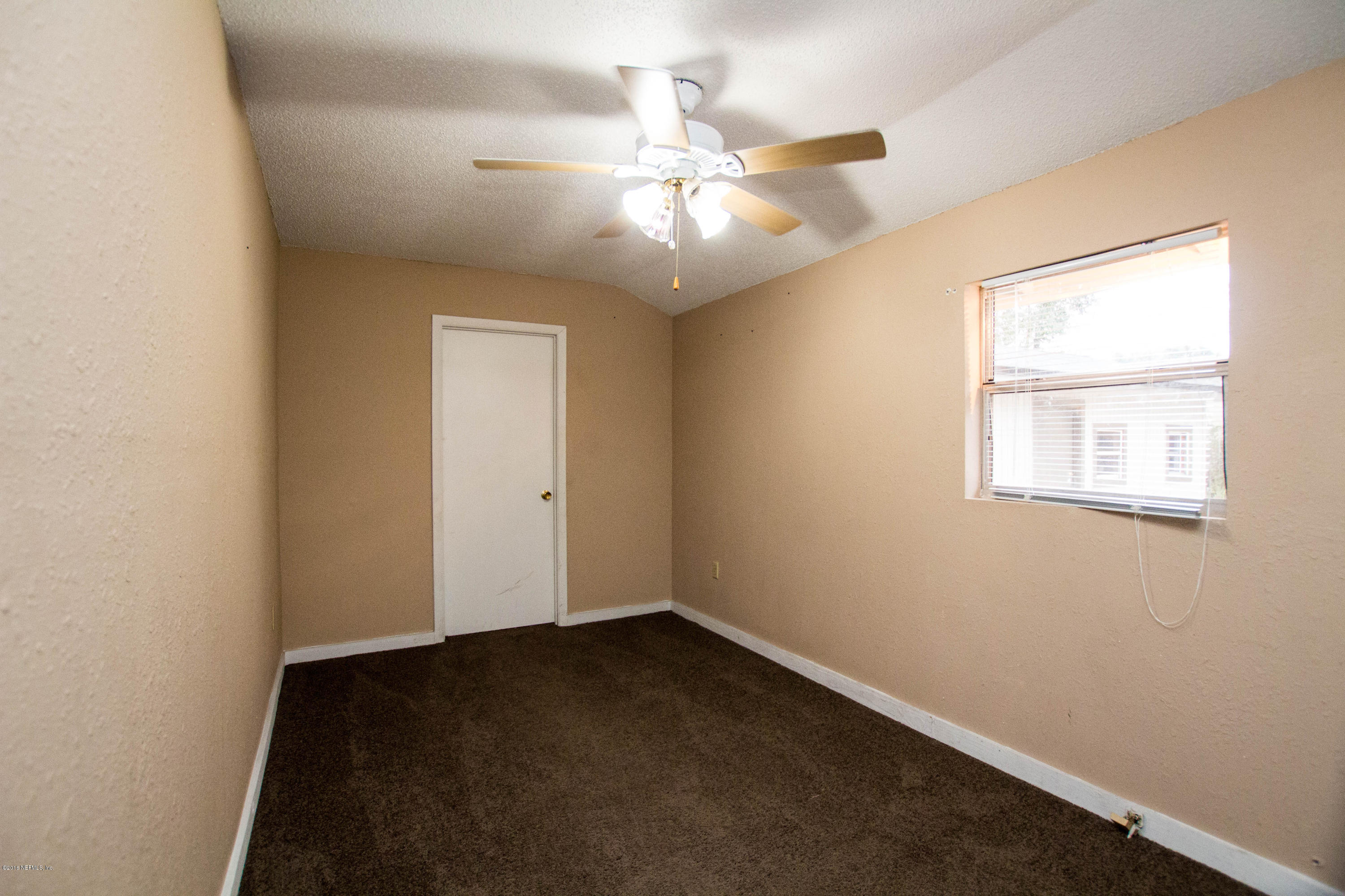 2839 Spring Park Road Jacksonville, FL 32207 - Photo 11 of 19 an empty room with a window and a fan
