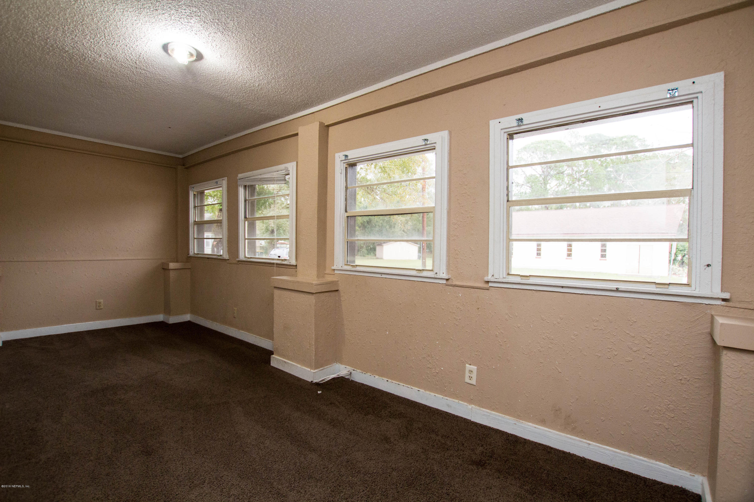 2839 Spring Park Road Jacksonville, FL 32207 - Photo 13 of 19 an empty room with wooden floor and windows