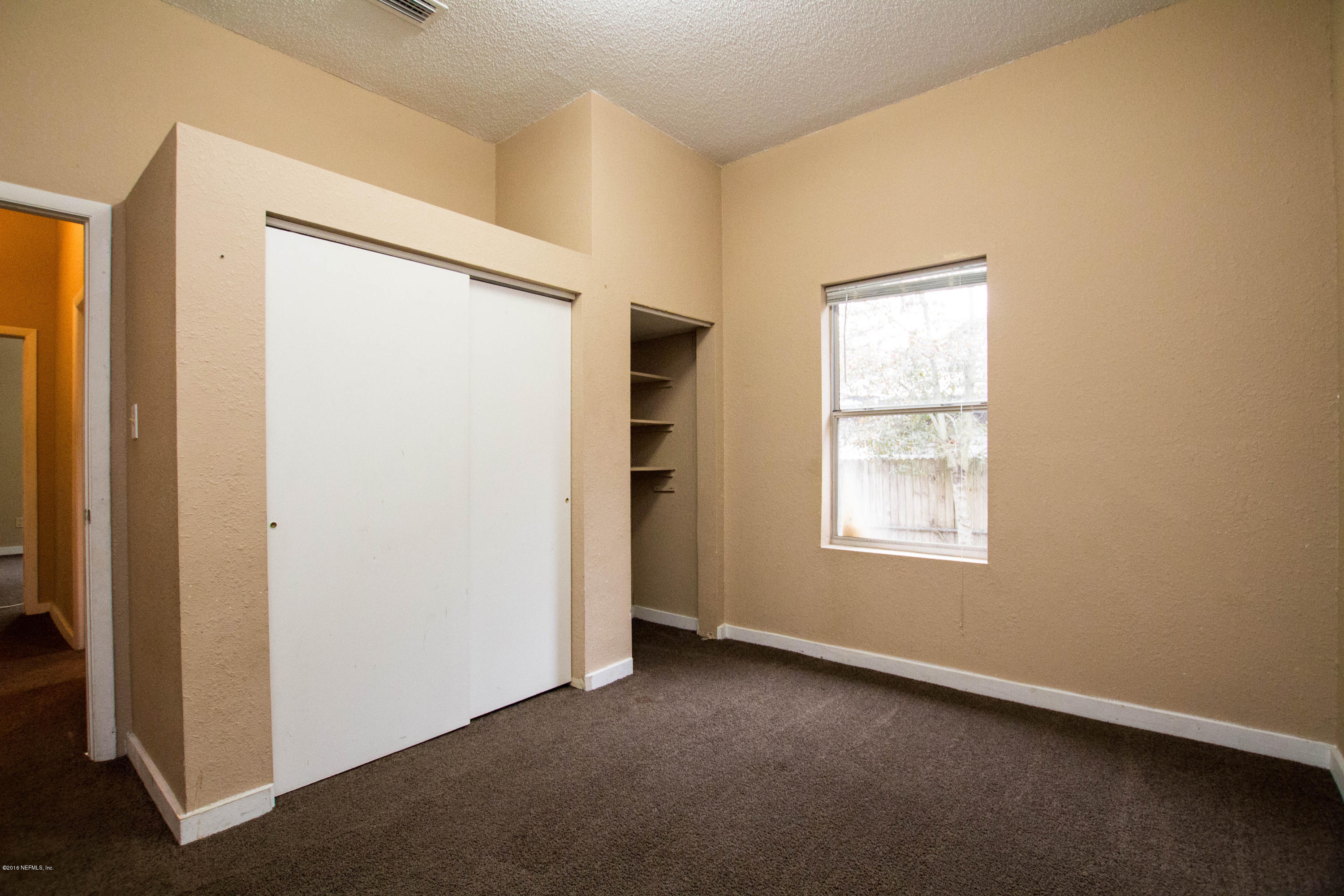 2839 Spring Park Road Jacksonville, FL 32207 - Photo 15 of 19 an empty room with windows and closet