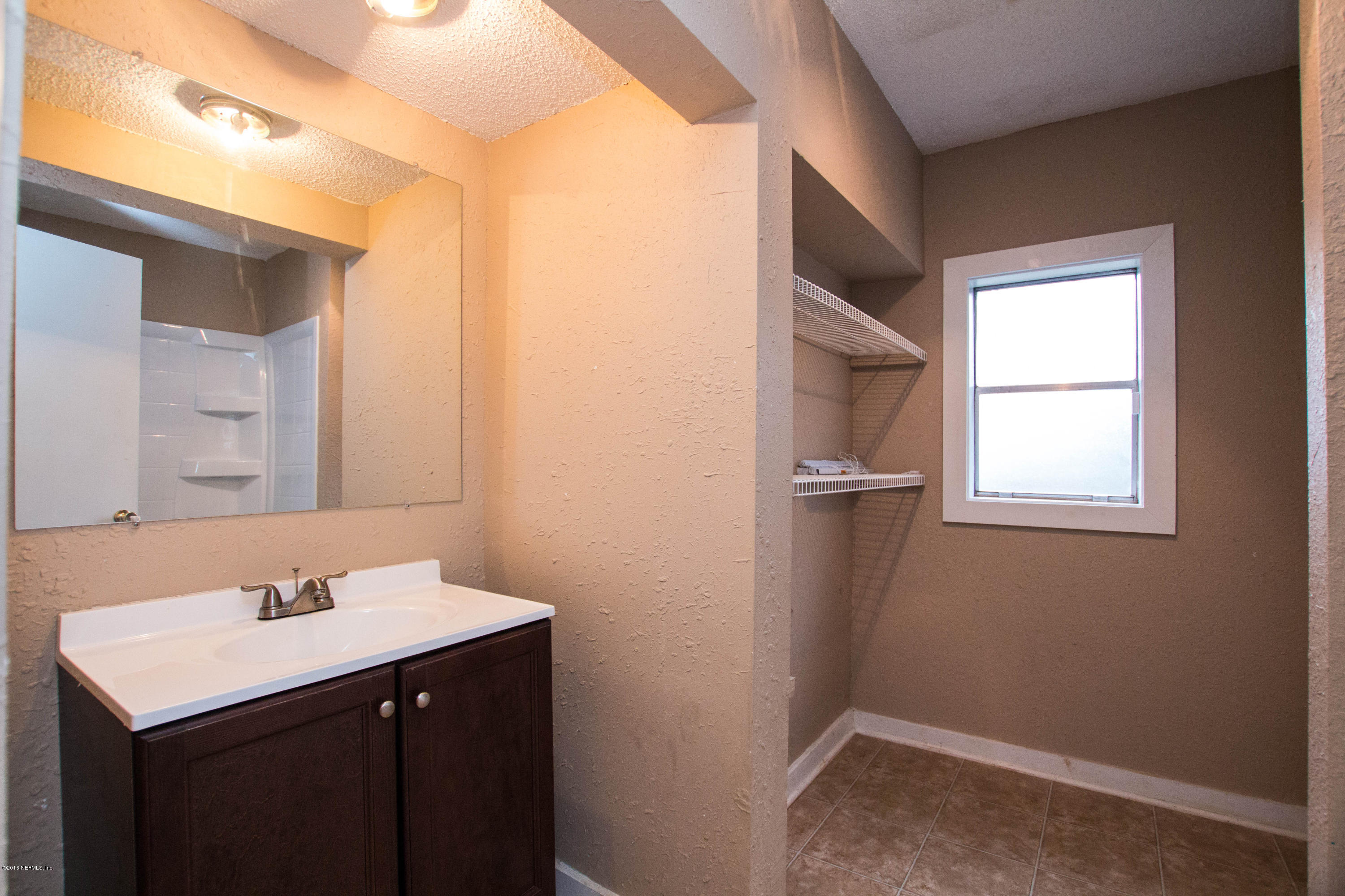 2839 Spring Park Road Jacksonville, FL 32207 - Photo 16 of 19 a bathroom with a sink a mirror and a toilet