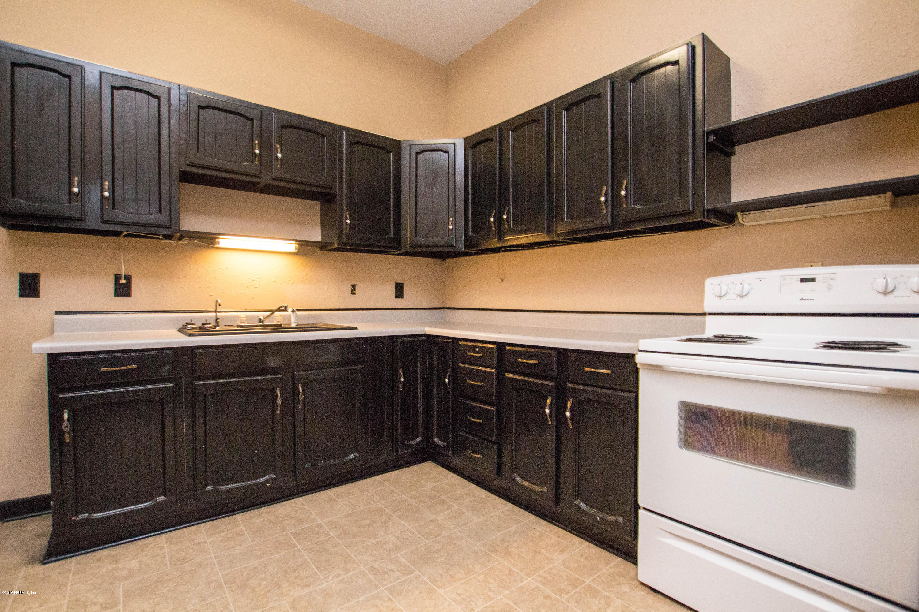 2839 Spring Park Road Jacksonville, FL 32207 - Photo 9 of 19 a kitchen with granite countertop wooden cabinets and white appliances