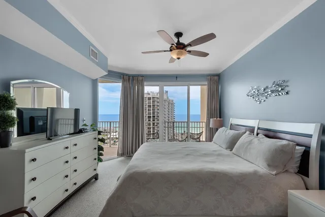 a bedroom with a large bed and a flat tv screen on dresser