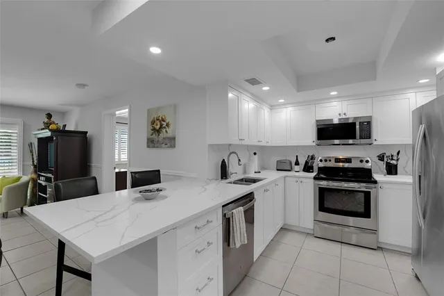 a kitchen with a sink stainless steel appliances and white cabinets