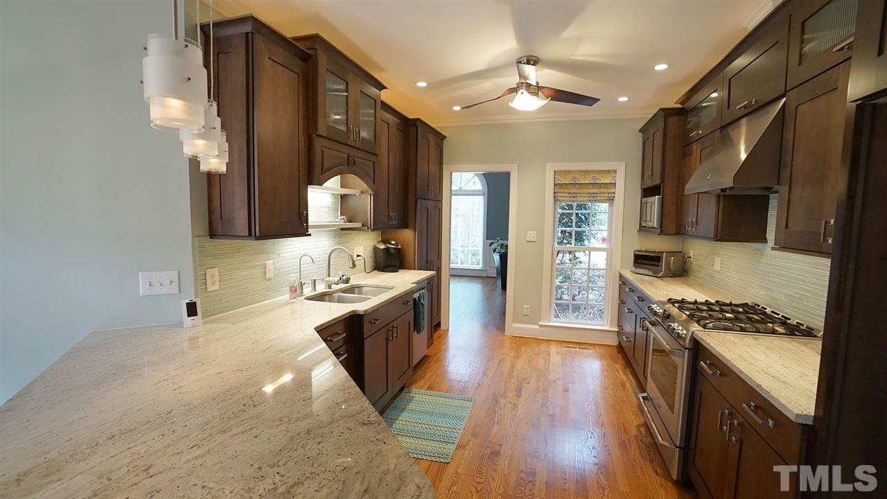 2708 Alloway Court Raleigh, NC 27606 - Photo 9 of 29 Newly renovated kitchen: New cabinets, granite, designer tile backsplash, 5 burner gas cooktop, stainless appliances, under cabinet lights, wine cooler and bar