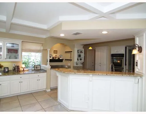 a large kitchen with granite countertop a sink and cabinets
