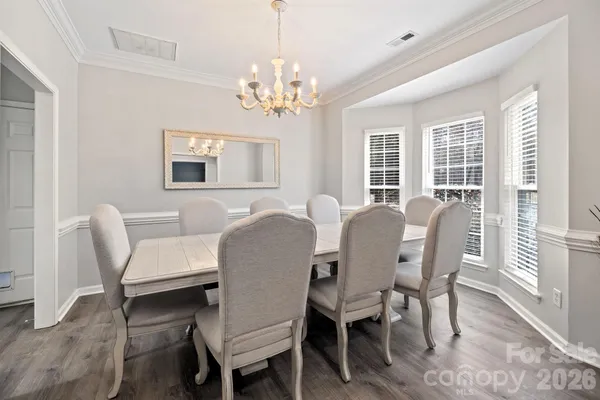 a view of a dining room with furniture a chandelier and wooden floor