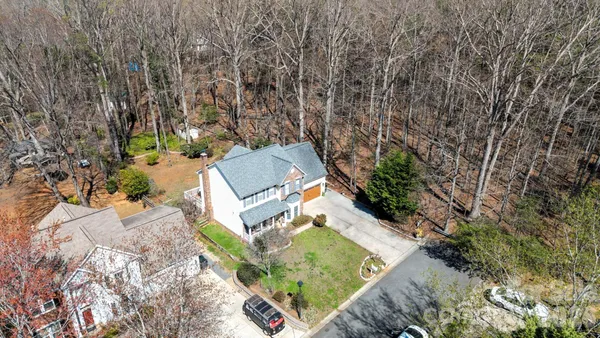 an aerial view of a house with a yard and lake view